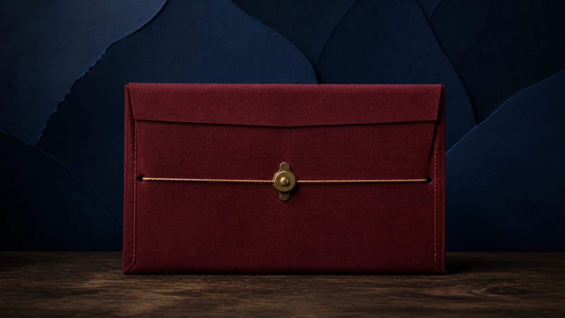 A closed oxblood book-cloth examination folio sealed with taut gold thread and an aged-brass tamper clasp.
